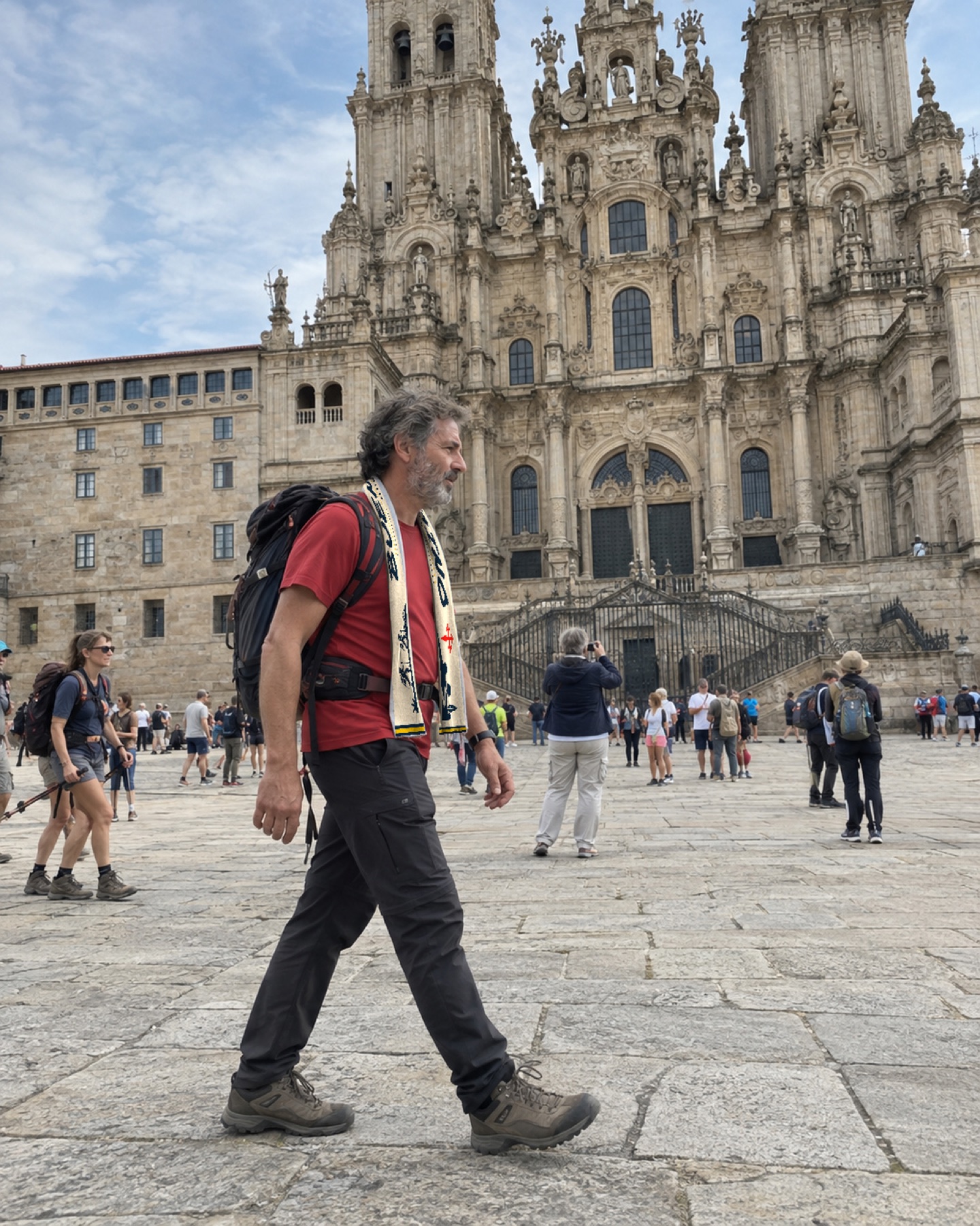 Peregrino con la bufanda azul caminando frente a la Catedral