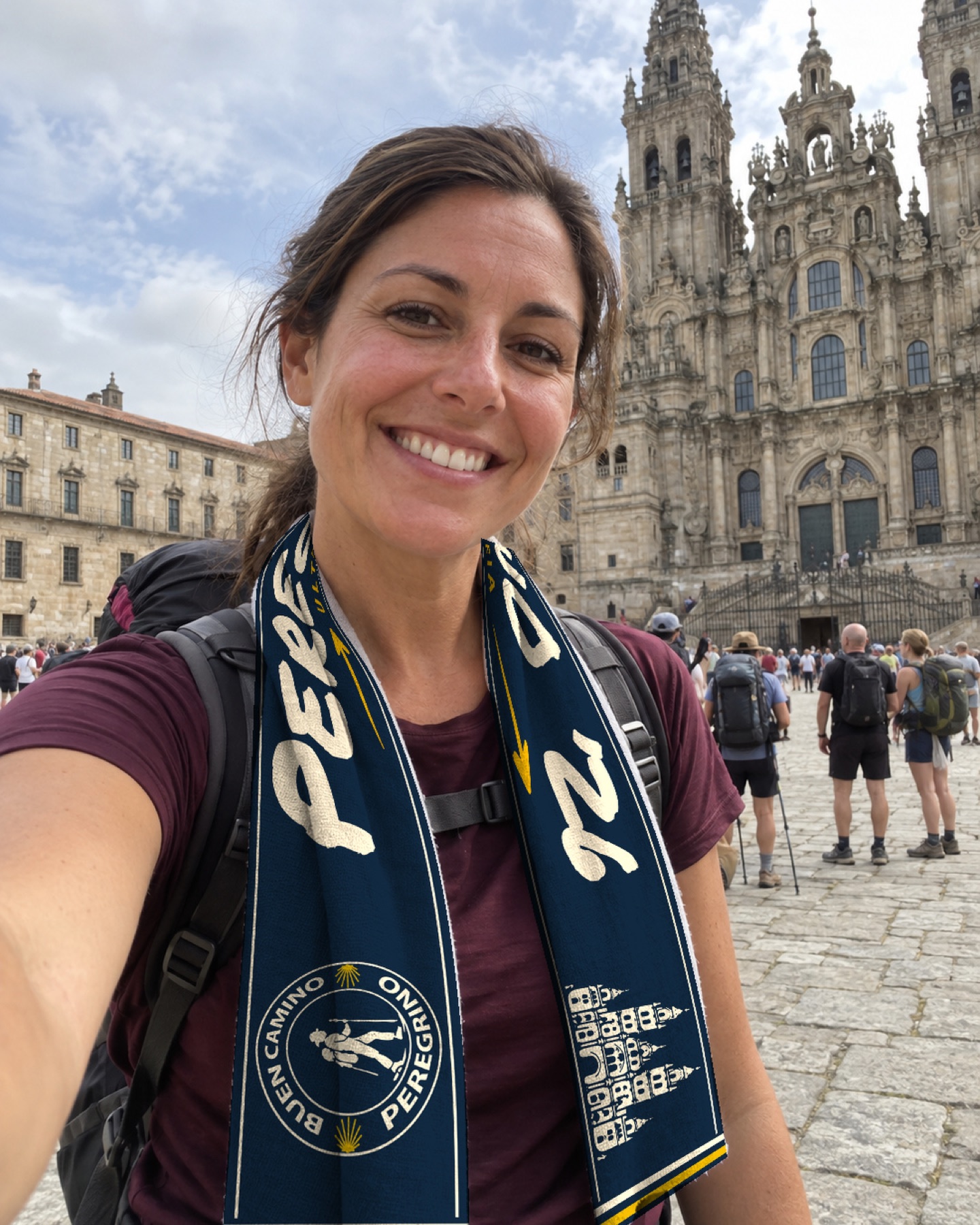 Peregrina con la bufanda azul y crema ante la Catedral de Santiago