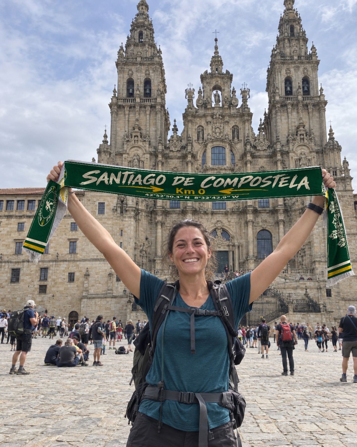 Peregrina muestra la bufanda verde frente a la Catedral de Santiago